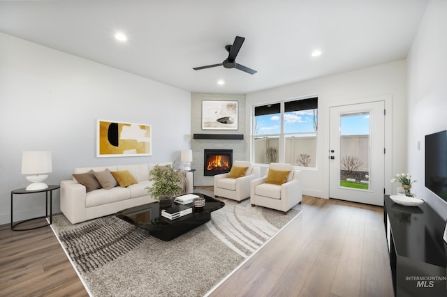 living room with recessed lighting, a fireplace, a ceiling fan, and wood finished floors