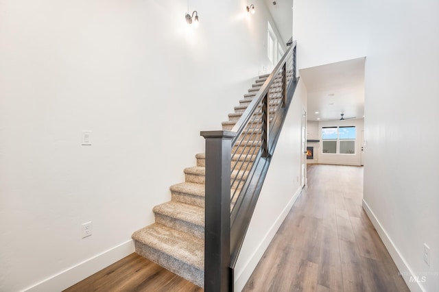 staircase featuring baseboards and wood finished floors