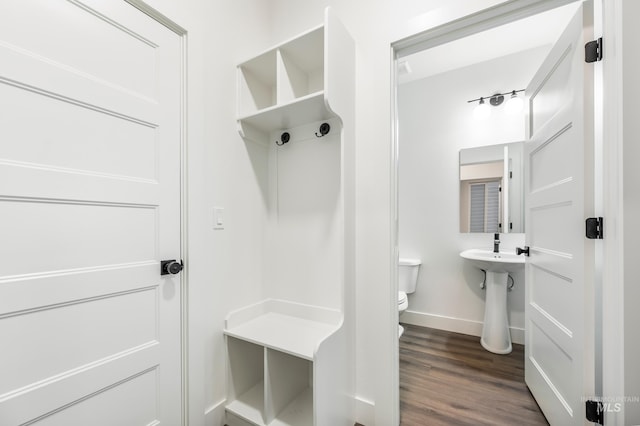 mudroom featuring dark wood-type flooring and baseboards