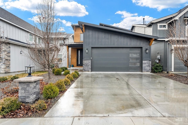 view of front of home featuring stone siding, an attached garage, and concrete driveway