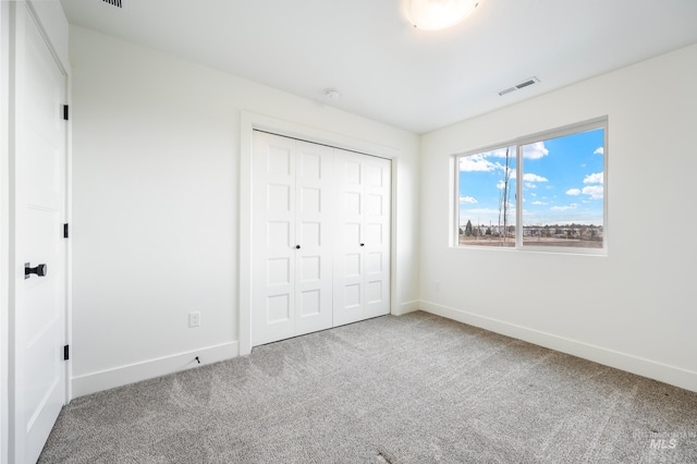 unfurnished bedroom featuring visible vents, baseboards, and carpet