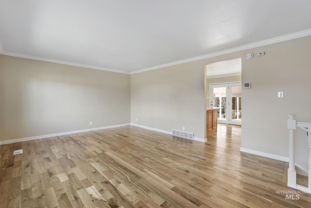 empty room featuring french doors, light hardwood / wood-style floors, and crown molding