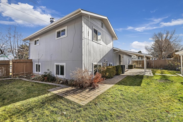 rear view of property with cooling unit, a yard, and a patio