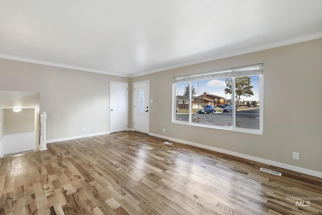 unfurnished living room featuring crown molding and light hardwood / wood-style flooring