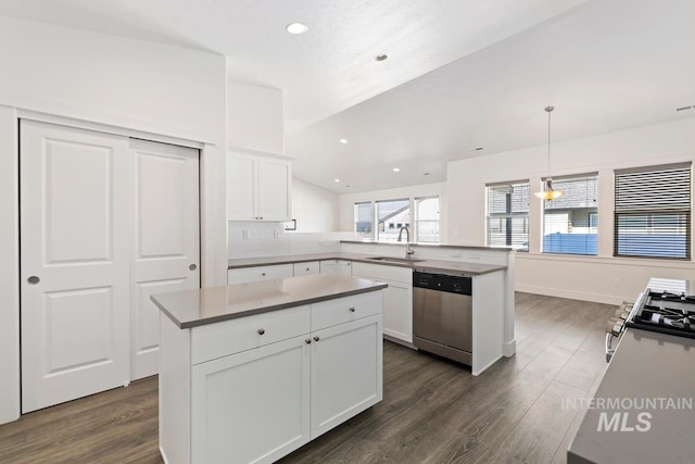 kitchen with hanging light fixtures, a kitchen island, stainless steel dishwasher, white cabinets, and sink