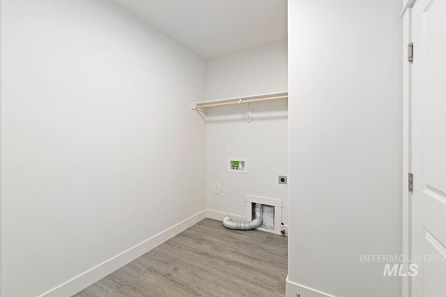 clothes washing area with light wood-type flooring, hookup for a washing machine, gas dryer hookup, and hookup for an electric dryer