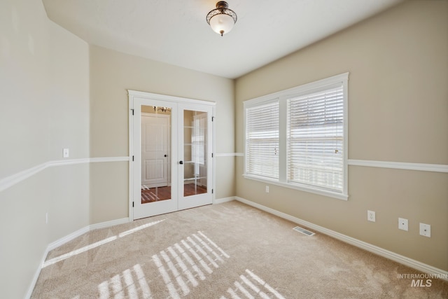 unfurnished room with light colored carpet and french doors