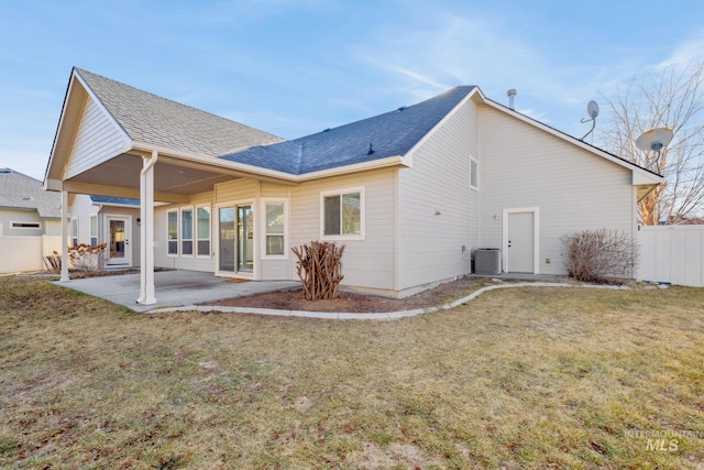 rear view of house with a patio area, a yard, and central AC