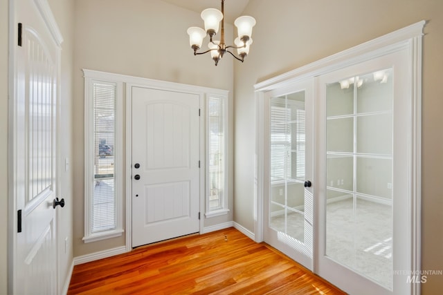 foyer with hardwood / wood-style flooring and a chandelier