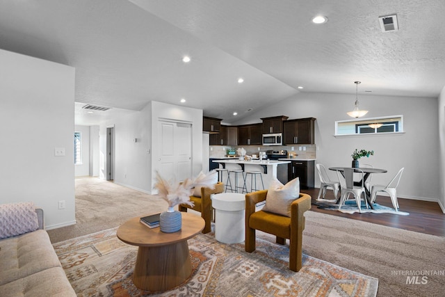 living room with a textured ceiling, carpet, and vaulted ceiling