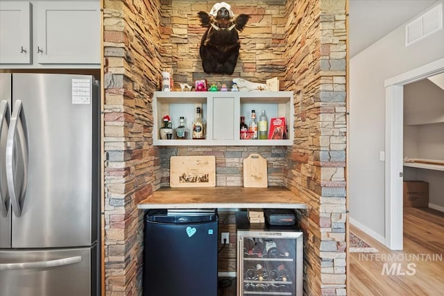 5006 Clearfield St, Caldwell, ID 83605 - indoor dry bar featuring freestanding refrigerator, beverage cooler, fridge, wood finished floors, and baseboards