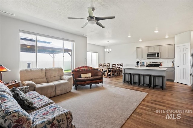 5006 Clearfield St, Caldwell, ID 83605 - living area with a chandelier, wood finished floors, a ceiling fan, recessed lighting, and a textured ceiling