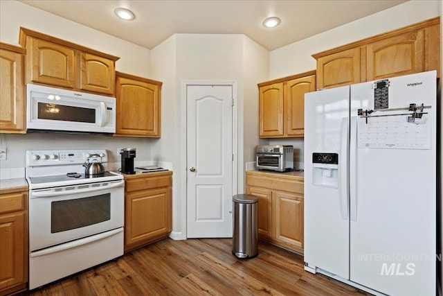 kitchen with white appliances and dark hardwood / wood-style floors