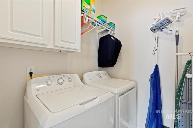 washroom with cabinets and washing machine and dryer