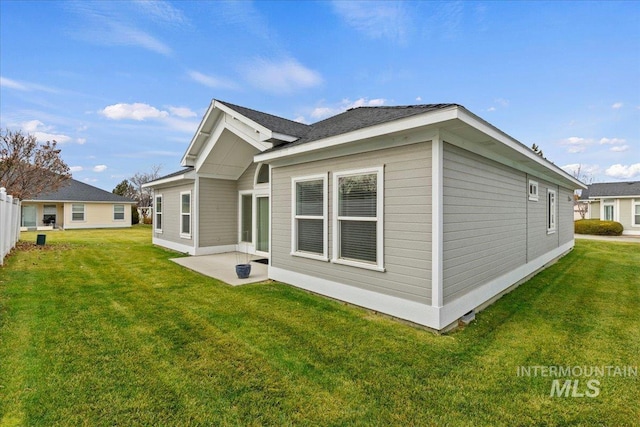 rear view of house with a lawn and a patio area