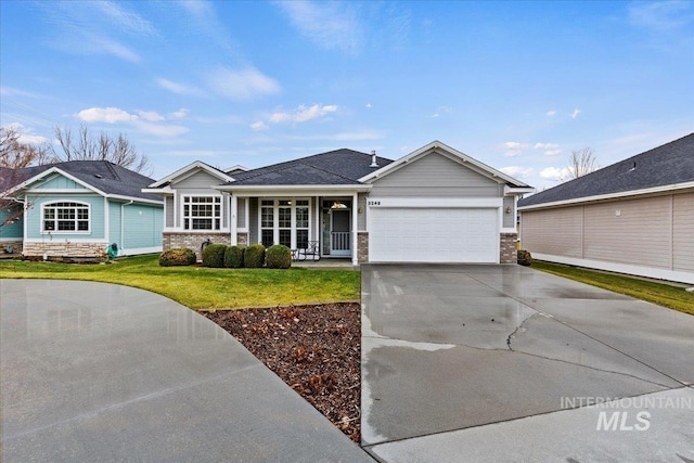 single story home featuring a front lawn, covered porch, and a garage