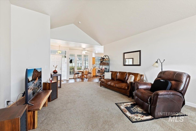 carpeted living room featuring ceiling fan and lofted ceiling