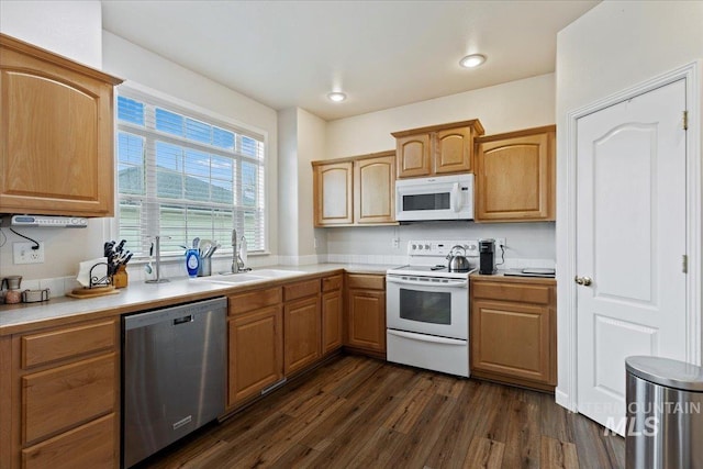 kitchen with white appliances, sink, and dark wood-type flooring