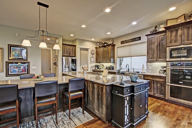 2468 E Lodge Trail Dr, Meridian, ID 83642 - kitchen with recessed lighting, a spacious island, stainless steel appliances, dark wood-type flooring, and backsplash