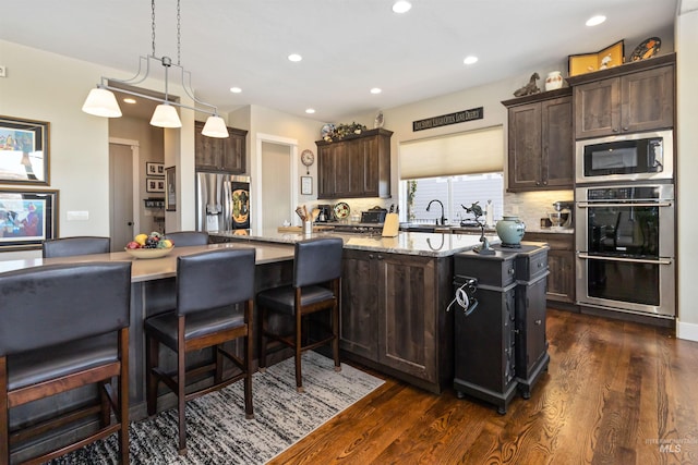 2468 E Lodge Trail Dr, Meridian, ID 83642 - kitchen with a sink, dark brown cabinets, stainless steel appliances, dark wood-type flooring, and backsplash