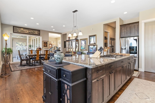 2468 E Lodge Trail Dr, Meridian, ID 83642 - kitchen with dark wood-style flooring, light stone counters, recessed lighting, a center island, and appliances with stainless steel finishes