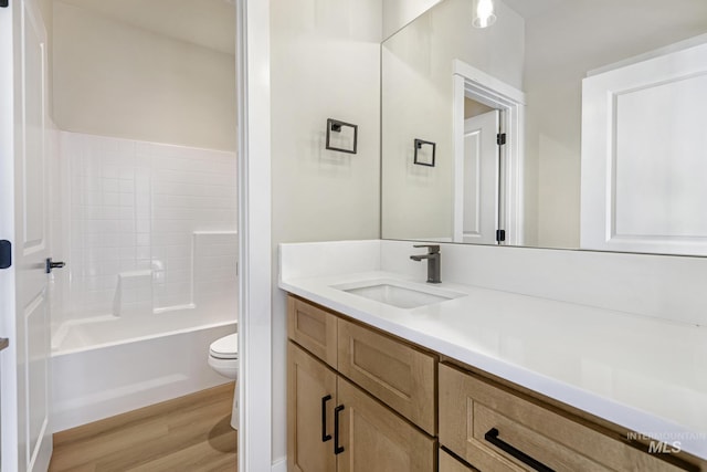 full bathroom with vanity, hardwood / wood-style floors,  shower combination, and toilet