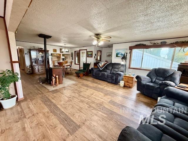 908 Pine St, Anatone, WA 99401 - living area featuring light wood-style floors, a textured ceiling, and a ceiling fan