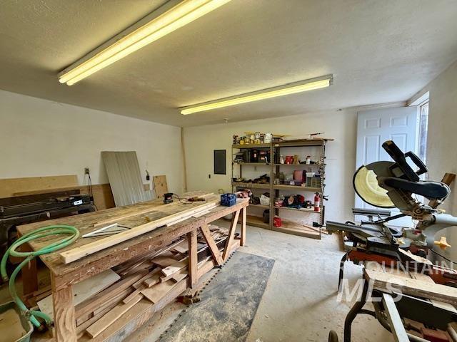 908 Pine St, Anatone, WA 99401 - miscellaneous room with a workshop area, electric panel, and unfinished concrete flooring