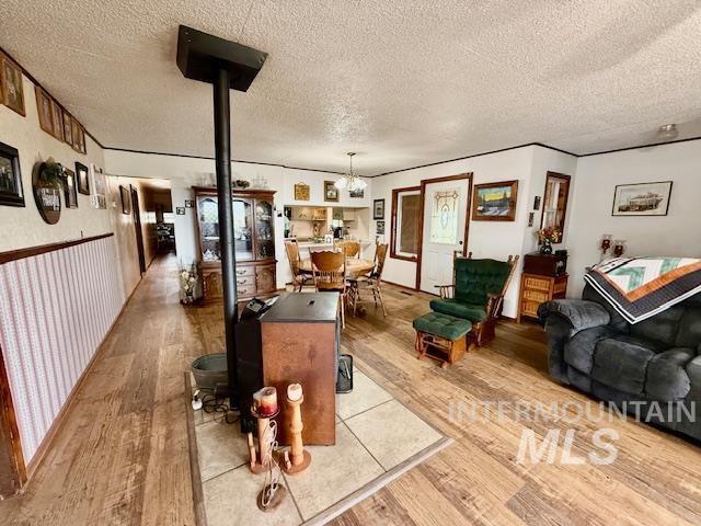 908 Pine St, Anatone, WA 99401 - living room featuring light wood finished floors, a textured ceiling, and a chandelier