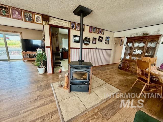 908 Pine St, Anatone, WA 99401 - detailed view of a wood stove, a textured ceiling, and wood finished floors