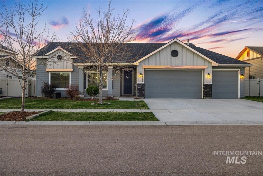 view of front of house with a gate, fence, an attached garage, a front lawn, and driveway