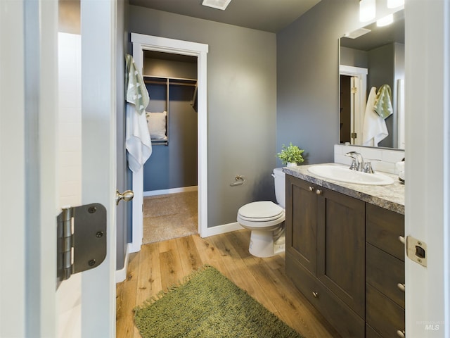 bathroom with toilet, wood-type flooring, and vanity