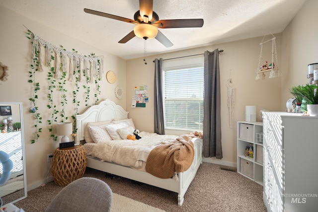 carpeted bedroom featuring ceiling fan and a textured ceiling