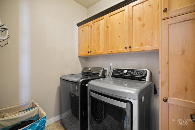 washroom with cabinets, tile patterned floors, and washing machine and clothes dryer