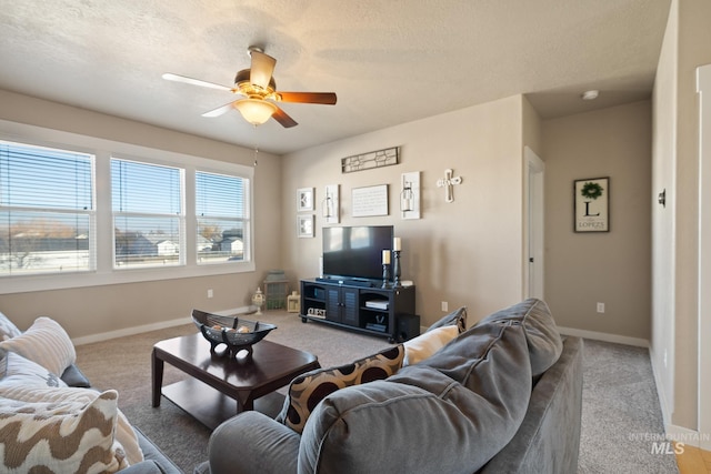 living room featuring a textured ceiling, carpet floors, and ceiling fan