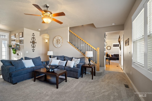 living room with light carpet, ceiling fan, and a healthy amount of sunlight