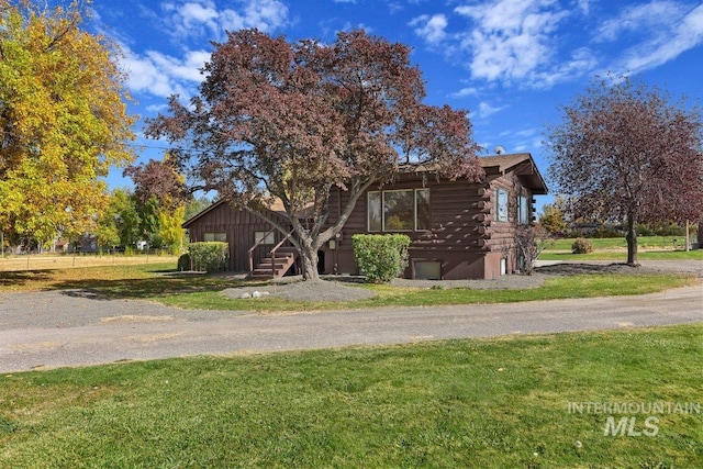 exterior space with log siding and a front yard