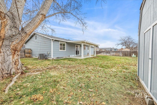 rear view of house featuring cooling unit, a yard, and a patio area