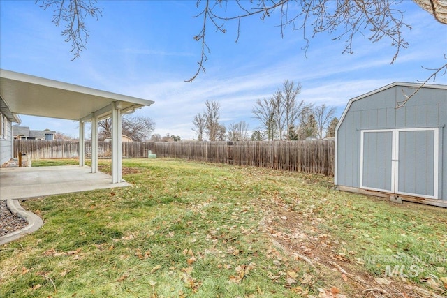 view of yard with a storage shed and a patio