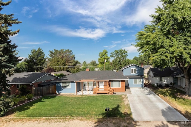 view of front of house featuring a front lawn, driveway, and fence