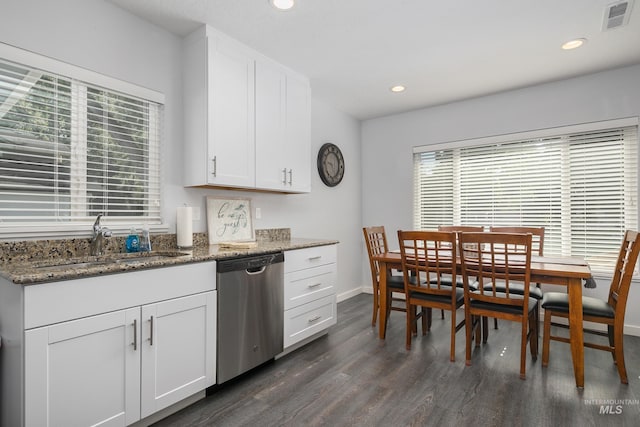 kitchen featuring stainless steel dishwasher, visible vents, stone countertops, and a sink