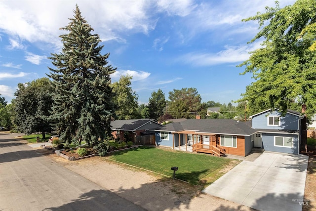 view of front of house with fence, a front lawn, and concrete driveway