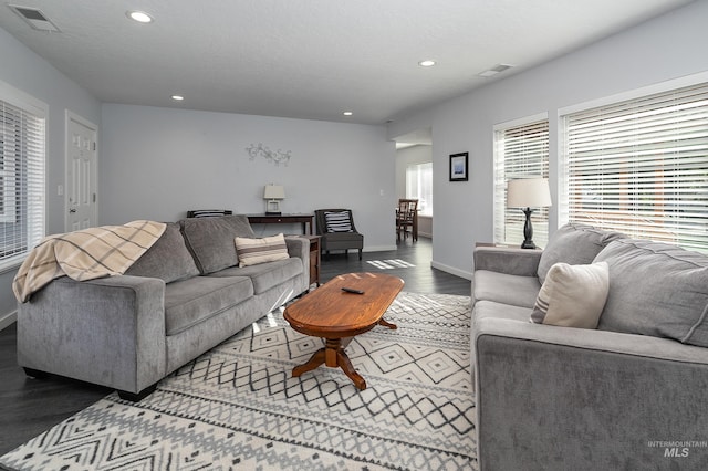 living area with baseboards, visible vents, wood finished floors, and recessed lighting