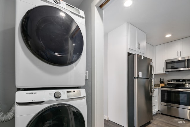 laundry room featuring stacked washer / dryer, recessed lighting, laundry area, and dark wood finished floors