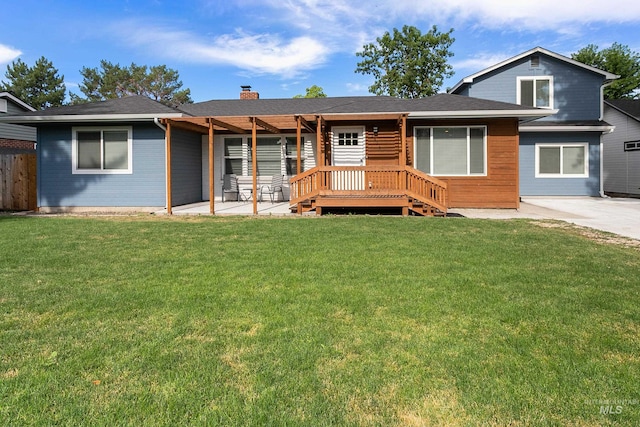 view of front of property with a patio, a chimney, and a front lawn