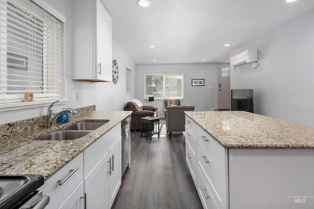 kitchen featuring a sink, stainless steel dishwasher, white cabinets, an AC wall unit, and dark wood-type flooring