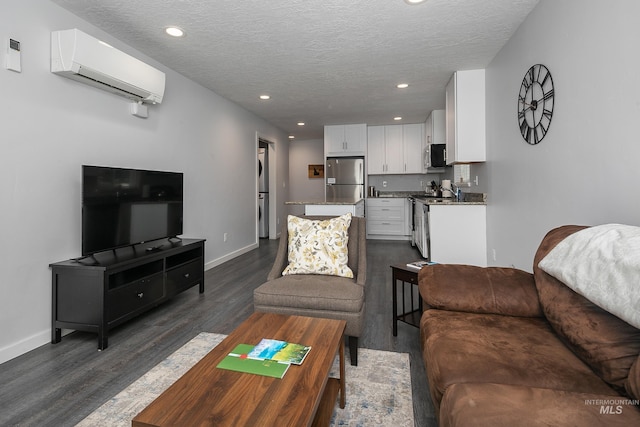 living area featuring dark wood finished floors, baseboards, a wall mounted AC, and a textured ceiling