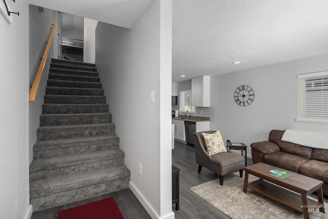 staircase with baseboards, a textured ceiling, wood finished floors, and recessed lighting