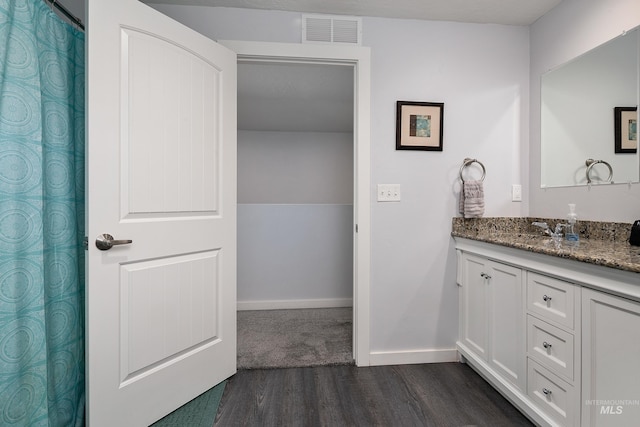 full bath with baseboards, visible vents, wood finished floors, and vanity