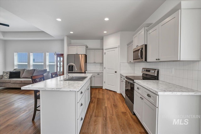 1275 Terra Ave, Twin Falls, ID 83301 - kitchen featuring stainless steel appliances, a kitchen breakfast bar, open floor plan, recessed lighting, and light countertops